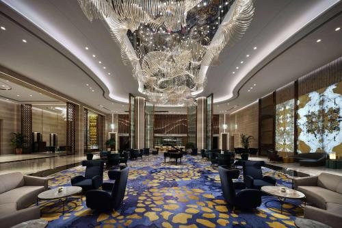 a lobby with chairs tables and a chandelier at Howard Johnson by Wyndham Jimei Lake Plaza Xiamen in Xiamen