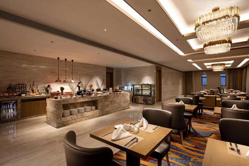 a restaurant with tables and chairs and a bar at Howard Johnson by Wyndham Jimei Lake Plaza Xiamen in Xiamen