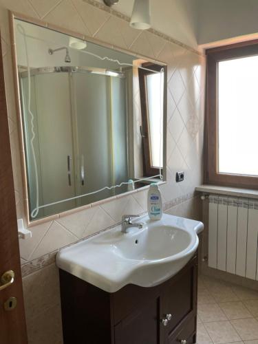 a bathroom with a sink and a large mirror at Villa Marilù in Pimonte