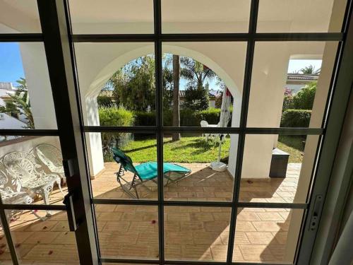 a view through a glass window of a patio at Casa Buccaneer, 2 Bedroom Garden Apartment in Praia da Luz in Luz