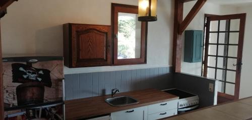 une cuisine avec un évier et une fenêtre dans l'établissement Le repaire des pirates, à Pietrosella