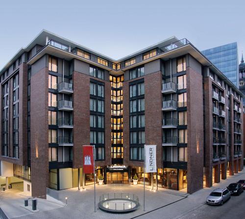 a large brick building with a table in front of it at Lindner Hotel Hamburg am Michel, part of JdV by Hyatt in Hamburg