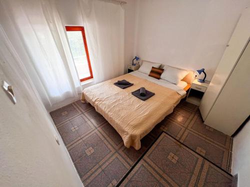 a small bedroom with a bed and a window at Robinson Ina 1 in Gdinj