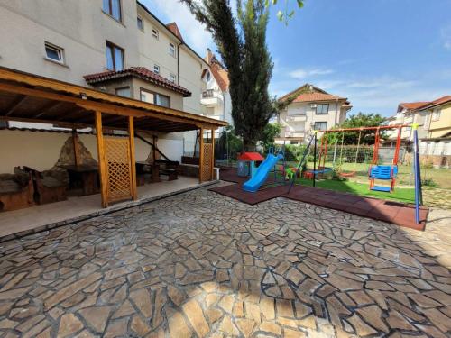 a playground with a slide and a swing at Guesthouse Iceberg in Ravda