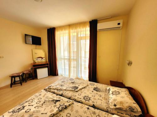a hotel room with a bed and a window at Guesthouse Iceberg in Ravda