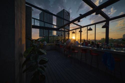 a deck with a bar with a sunset in the background at Sapiens Hotel in Tashkent