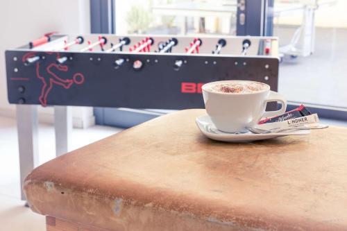 a cup of coffee sitting on top of a table at Lindner Hotel Frankfurt Sportpark, part of JdV by Hyatt in Frankfurt/Main