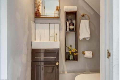 een kleine badkamer met een wastafel en een spiegel bij Apple Tree Cottage in Oxford