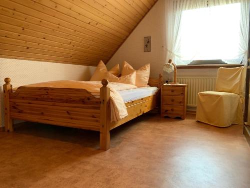 a bedroom with a wooden bed and a window at Gisela Hollmann in Groß Wittensee