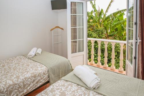 a room with two beds and a balcony at Pata da Gaivota Boutique House in Lourinhã