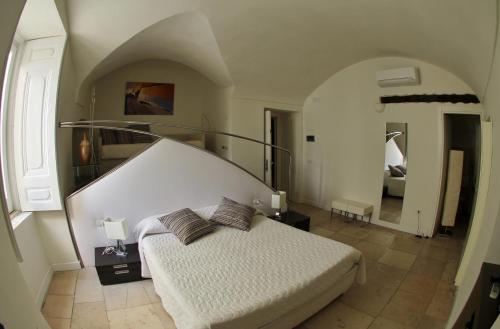 a bedroom with a white bed and a staircase at Edificio 15 House Elite in Rodi Garganico
