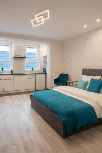 a bedroom with a large bed and a kitchen at Vár Apartman in Eger