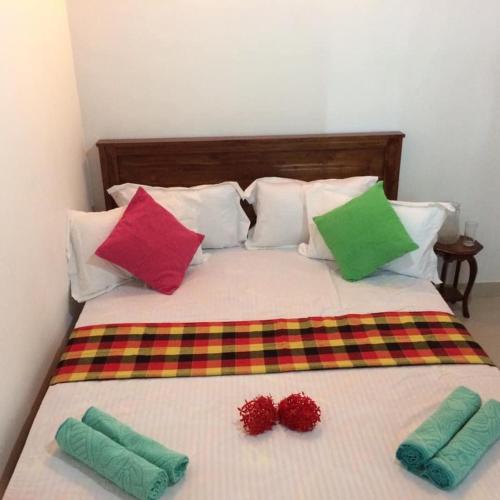 a bed with colorful pillows on top of it at Villa25 Homestay free pick up from the centre in Kandy