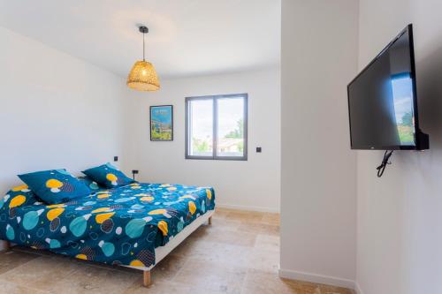 une chambre avec un lit et une télévision à écran plat dans l'établissement La Villa de l'Olivier - Maison climatisée pour 6, à Saint-Victor-la-Coste