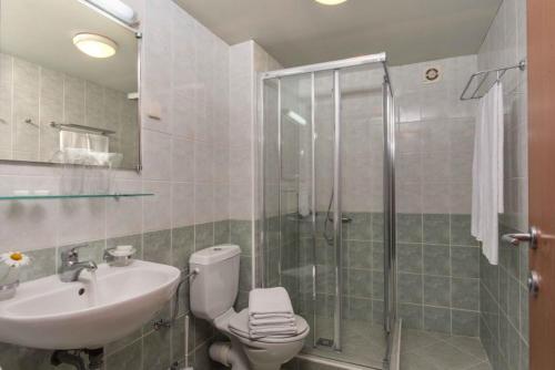 W łazience znajduje się prysznic, toaleta i umywalka. w obiekcie Hotel Pomorie Sun w Słonecznym Brzegu