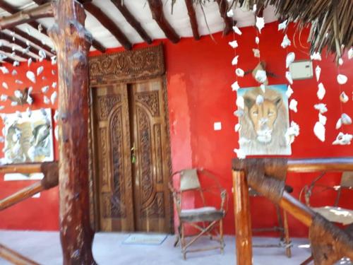 a room with red walls and a wooden door at Karibu Paradaizi in Michamvi