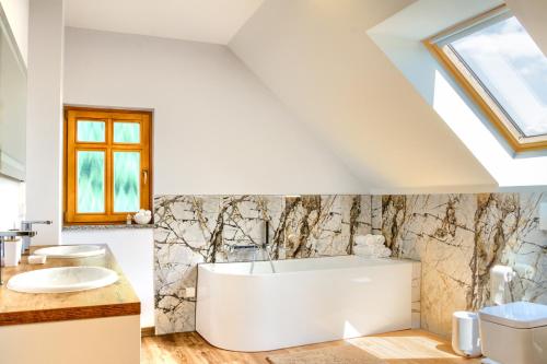 a bathroom with a white tub and a sink at Gray Wings Home 