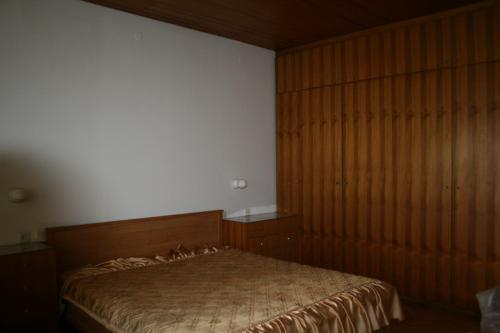 ein Schlafzimmer mit einem Bett und einer Holzwand in der Unterkunft Downtown Gem Apartment in Sarajevo