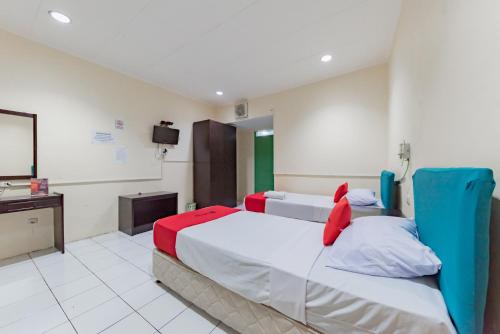 a hotel room with two beds and a flat screen tv at RedDoorz @ Jalan R.E. Martadinata Sukabumi in Sukabumi