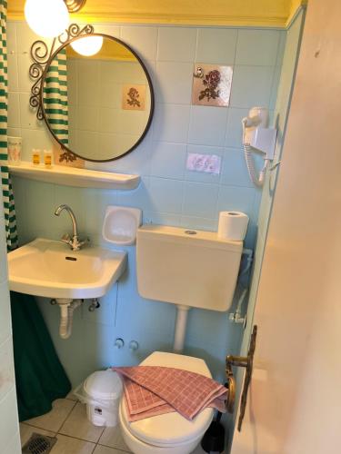 a bathroom with a sink and a toilet and a mirror at Villa Corfiota Moraitika Beach in Moraitika