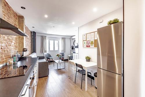 a kitchen and living room with a stainless steel refrigerator at Ático Centro de Madrid in Madrid