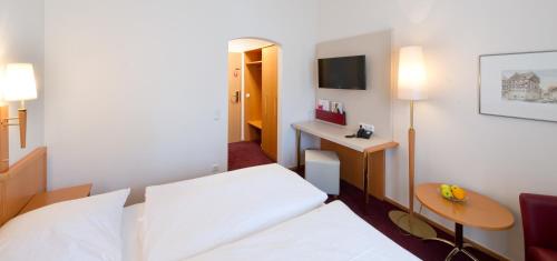 a hotel room with a bed and a desk at Altmann's Stube in Erlangen