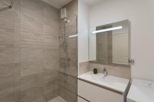 une salle de bain avec une douche, un lavabo et un miroir dans l'établissement Bahibé - Balcon et parking au calme proche gare, à Rennes