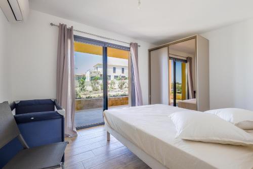 a bedroom with a large bed and a large window at Villa Lurenzu - Maison pour 8 avec piscine in Belgodère