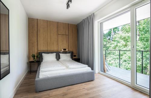 una camera da letto con un letto e una grande finestra di Apartamenty na Wydmach a Pobierowo