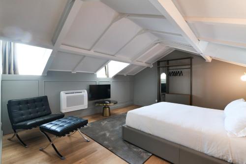 a bedroom with a bed and a chair and a television at PRESTIGE BOUTIQUE APARTHOTEL - Piazza Duomo View in Milan