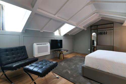 a bedroom with a bed and a chair and a tv at PRESTIGE BOUTIQUE APARTHOTEL - Piazza Duomo View in Milan