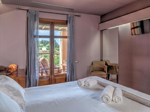 a bedroom with a bed with towels on it at Fiscardo Bay Hotel in Fiskardo