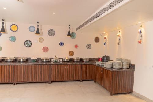 um restaurante com pratos na parede e um balcão em Hotel Citrus Prime Candolm, Goa em Candolim