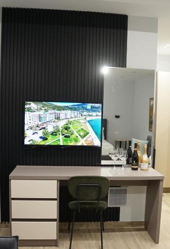 a desk with a flat screen tv on a wall at Palm Side Hotel in Vlorë