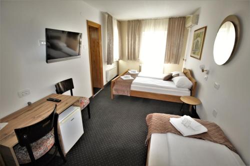 a hotel room with two beds and a desk at Pansion Stari Grad in Sarajevo