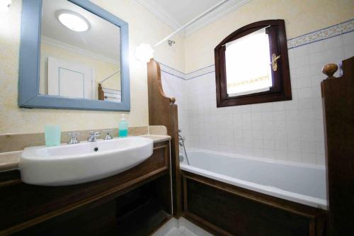 a bathroom with a sink and a tub and a mirror at Villa Camilla in Stintino