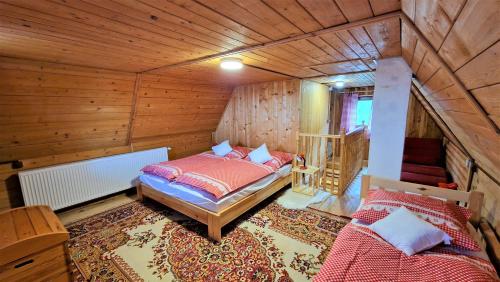 Chata Holý Vrch - oáza kľudu a pokoja في Krupina: غرفة نوم بسريرين في كابينة خشبية