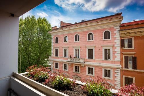 un edificio rosa con alberi e fiori su un balcone di B&B Home 77 a Roma