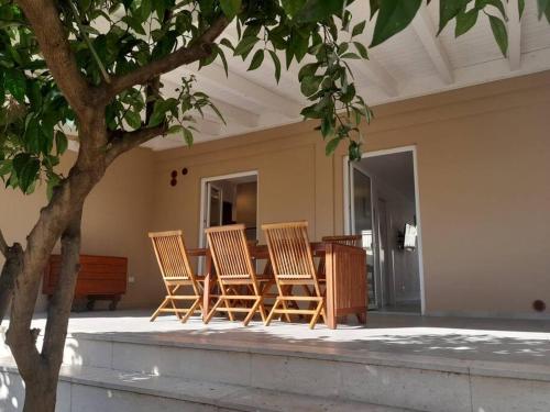 a group of chairs sitting around a table on a patio at Elegante monolocale Elmas Cagliari in Elmas