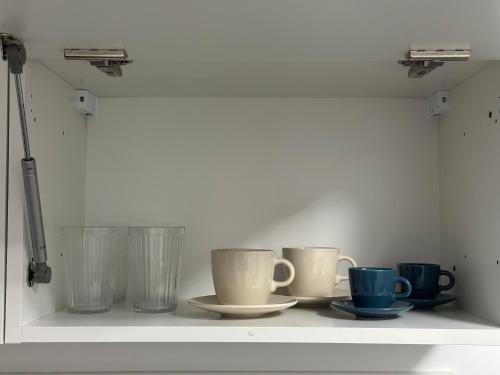 a shelf with cups and glasses on it at Apart Nissa Bella Seafont / Promenade des Anglais in Nice