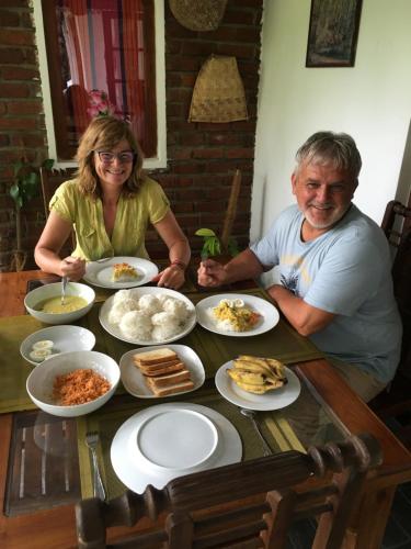 a man and woman sitting at a table with food at Villa25 Homestay free pick up from the centre in Kandy
