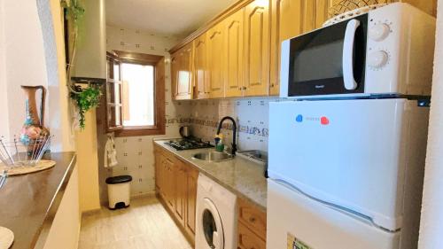 a kitchen with a white refrigerator and a microwave at Beautiful apartment near LaMata Beach with PANORAMA SEA view!!! in Torrevieja