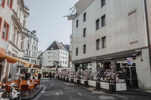 een stadsstraat met gebouwen, tafels en stoelen bij Boutique Hotel Cologne in Keulen