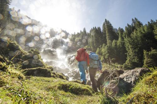 a man with a backpack walking down a trail at Alpenpension Pfurtscheller in Neustift im Stubaital