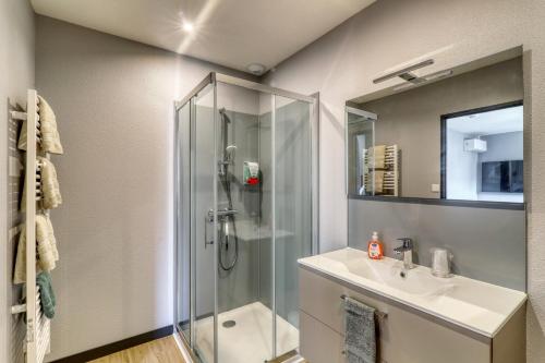 La salle de bains est pourvue d'une douche et d'un lavabo. dans l'établissement Résidence des Postes 1, à Dompierre-sur-Besbre