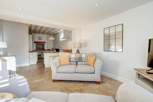 a living room with a couch and a kitchen at Friday Cottage in Wheatley