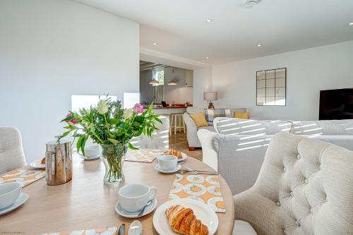 a dining room with a table with a vase of flowers at Friday Cottage in Wheatley
