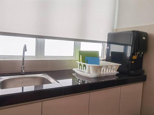 eine Küchentheke mit einer Spüle und einer Mikrowelle in der Unterkunft Emerald Avenue Cozy 3R3B Apartment 830 in Brinchang