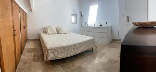 une petite chambre avec un lit et un lavabo dans l'établissement Haut de villa vue mer, à La Seyne-sur-Mer