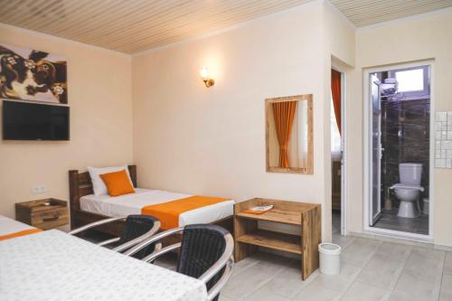 a room with two beds and a table and a window at MALİBEACH APART OTEL in Seferihisar